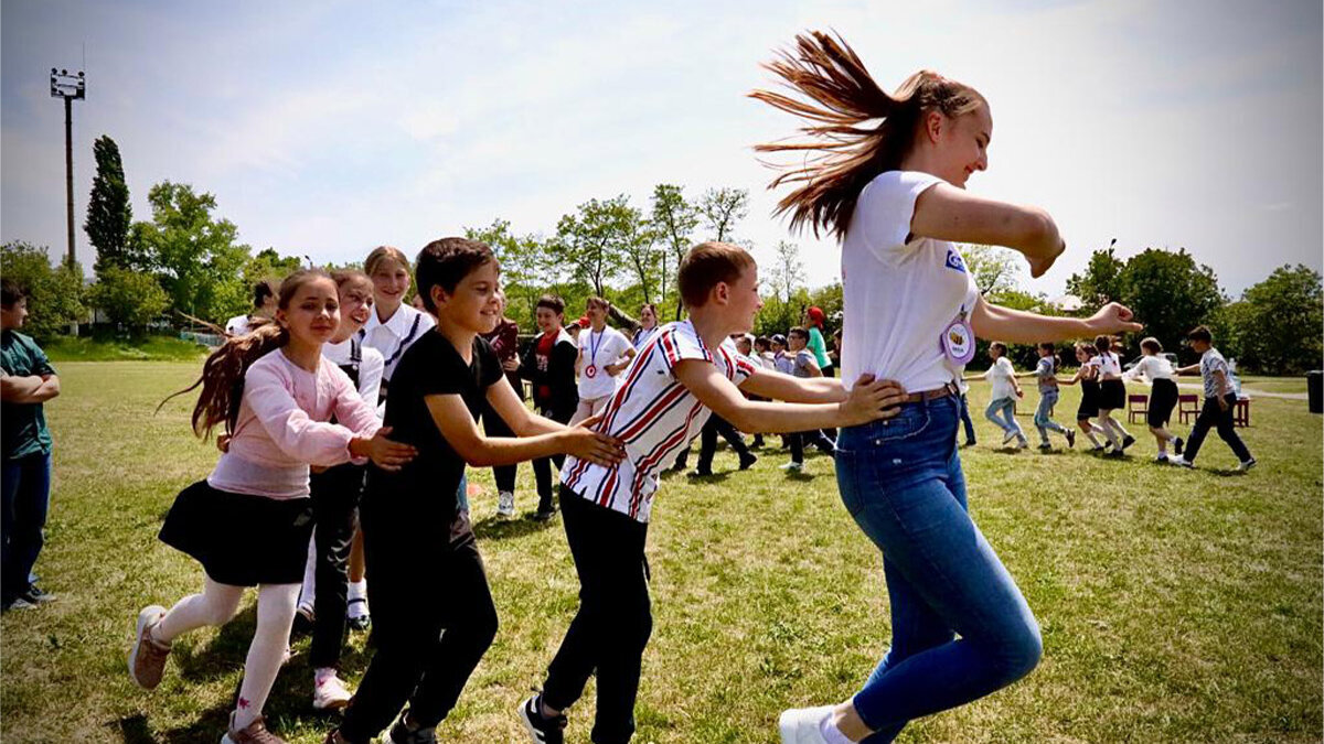Ukrainische Kinder spielen gemeinsam auf einer grünen Wiese 