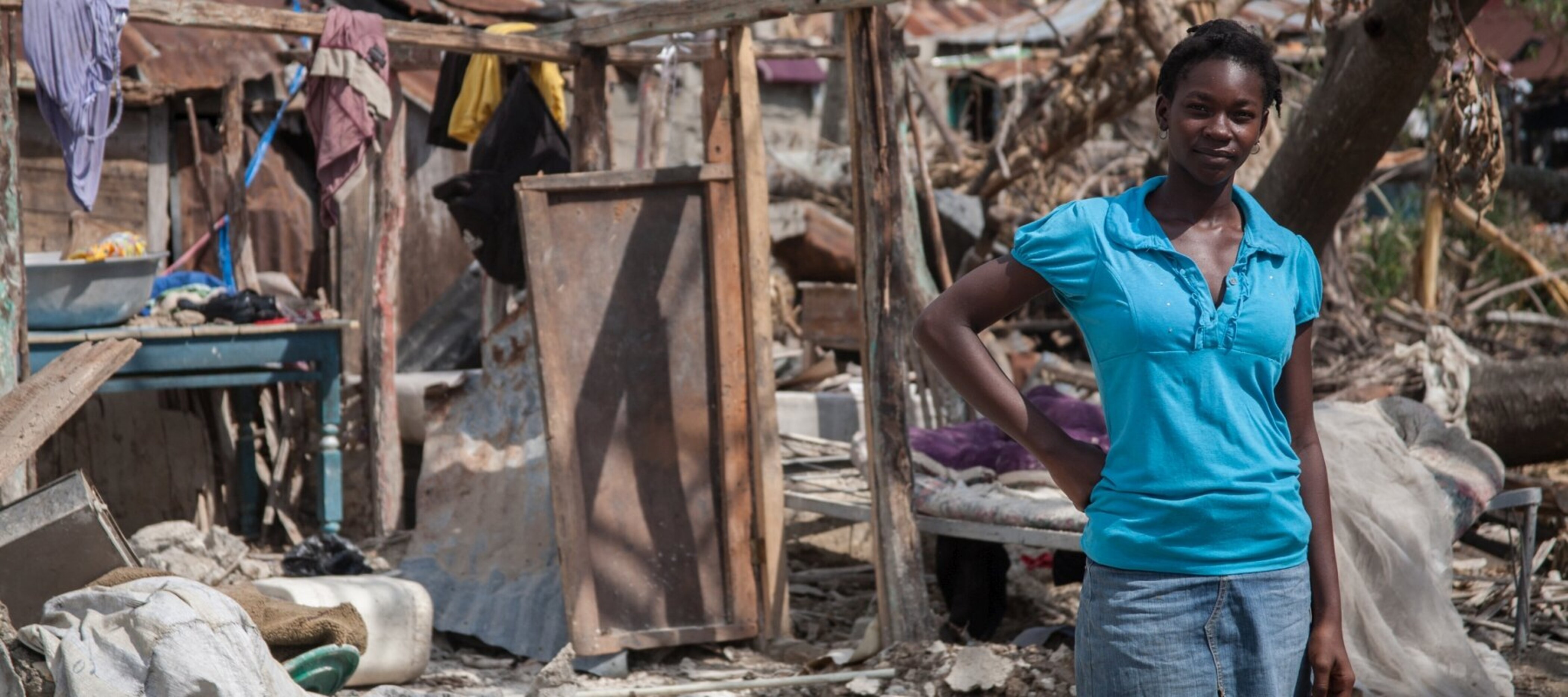 Eine Haitianerin vor den Trümmern ihres Hauses 