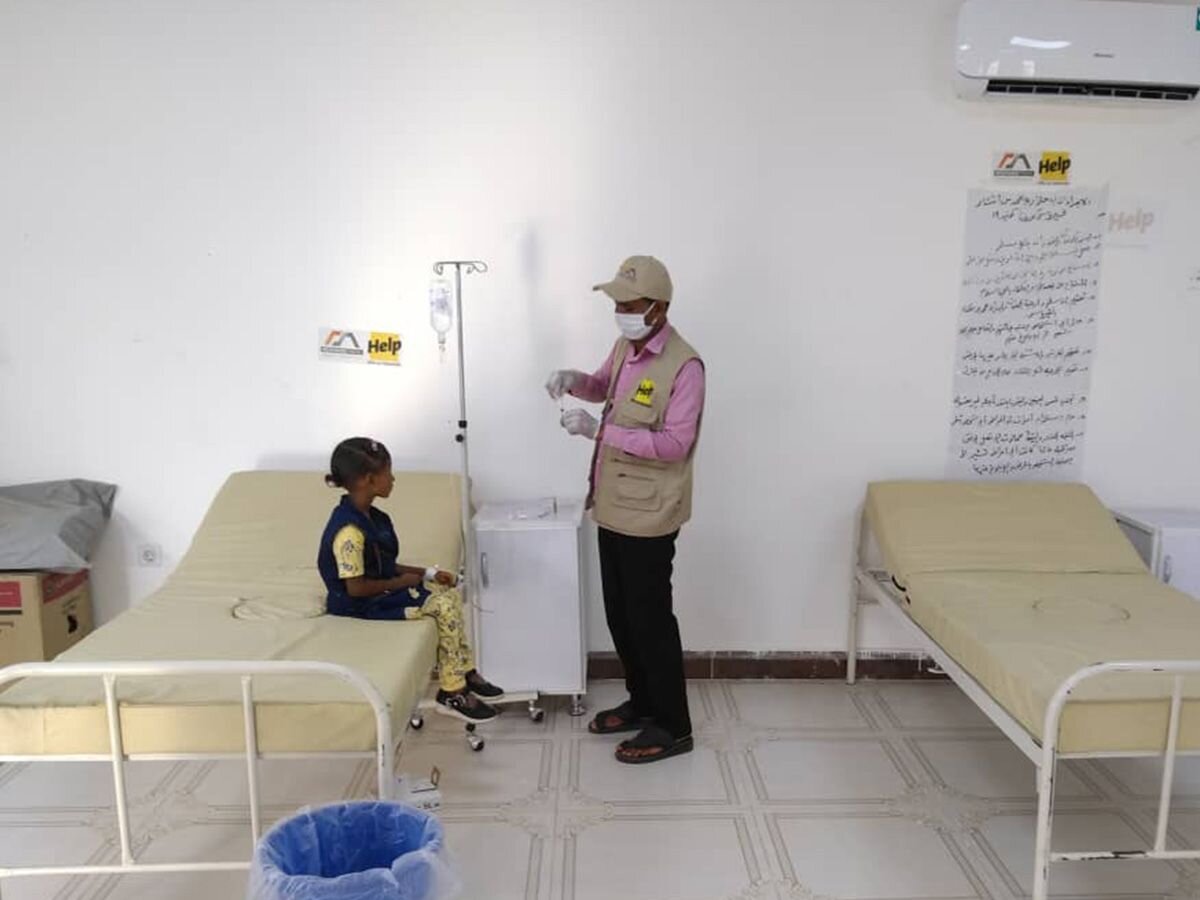 Help-Mitarbeiter mit Kind in Behandlungszentrum gegen Cholera