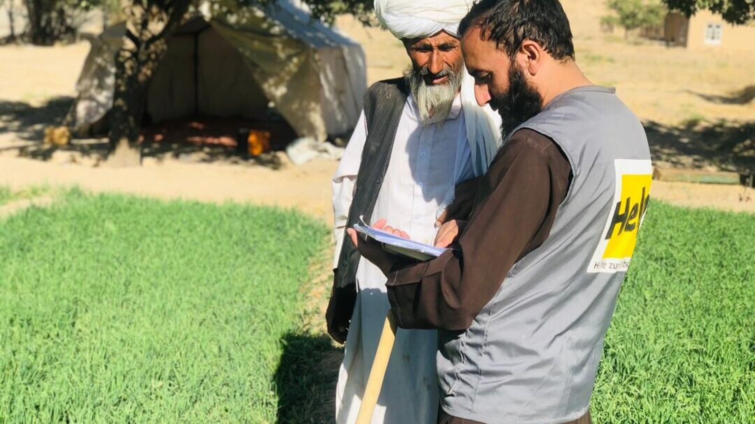 Ein Help-Mitarbeiter im Gespräch mit einem afghanischen Landwirt