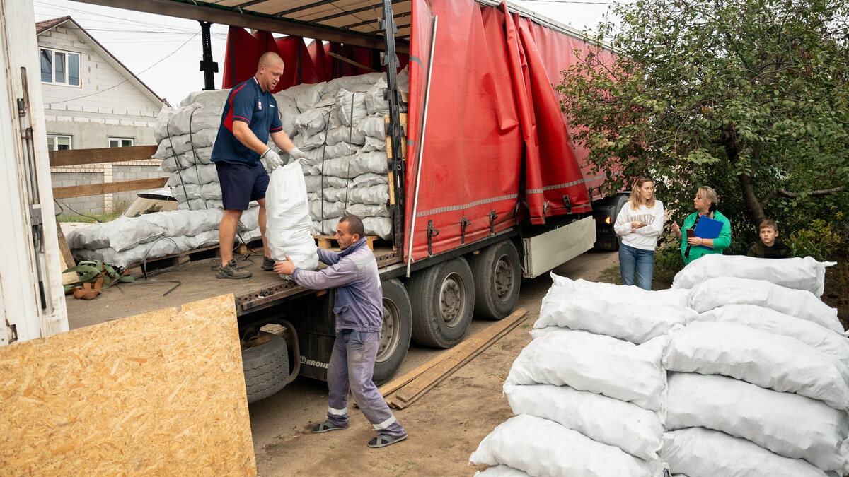 Helfer verteilen Heizbriketts an Familien in der Ukraine