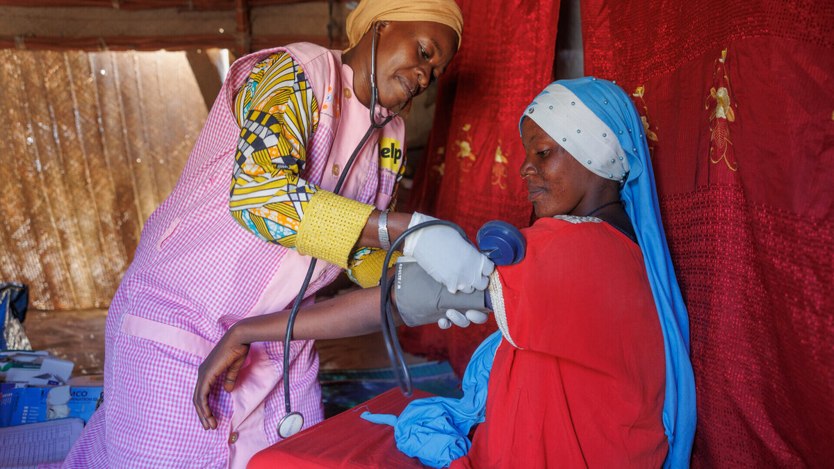  A Malian midwife measures a patient's blood pressure