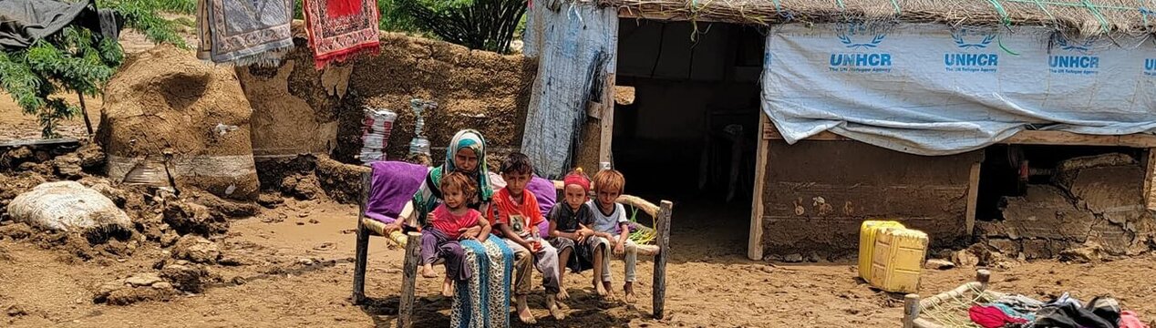 Eine jemenitische Frau und ihre Kinder sitzen vor ihrem Wohnhaus, das von den Überschwemmungen betroffen war.