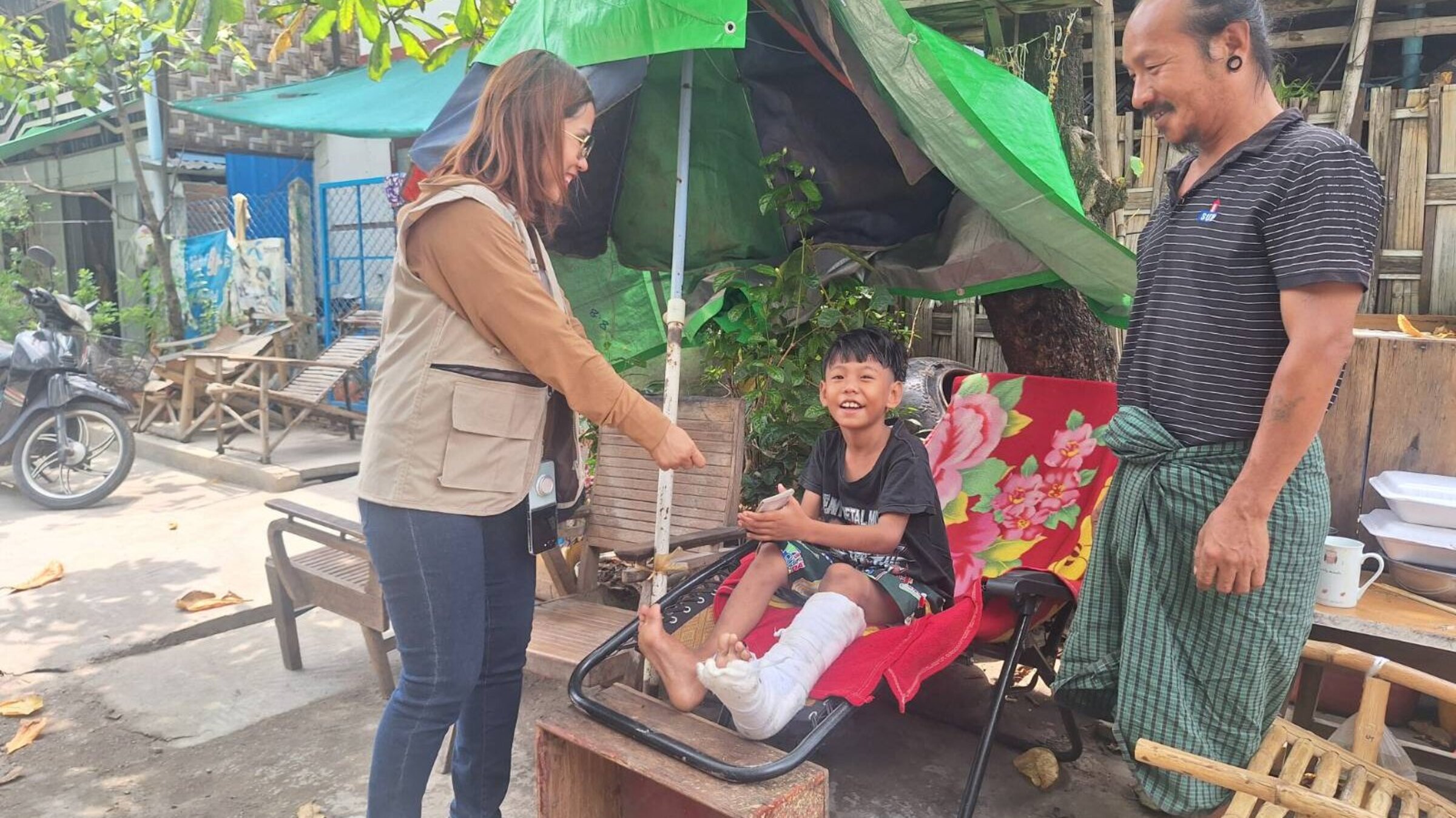 A child with a broken leg receives support
