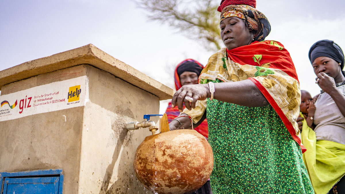 Development cooperation to improve the drinking water supply in Mali A Malian woman draws drinking water from a well built by Help
