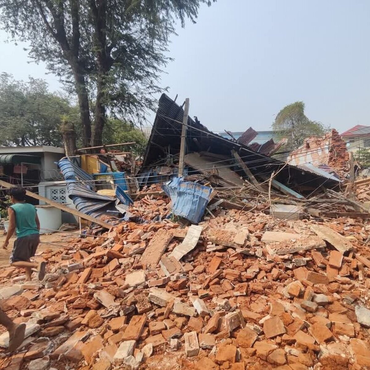 Zerstörung nach dem Erdbeben in Myanmar Menschen laufen an Trümmern in Myanmar vorbei
