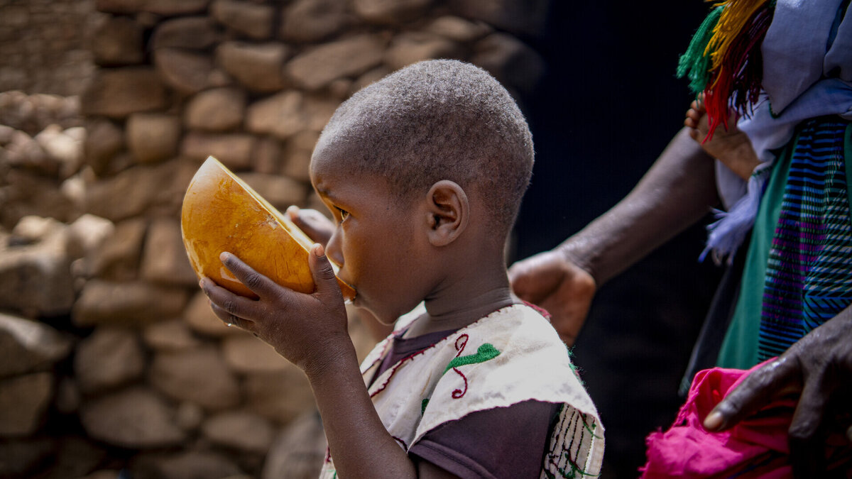 Für Kinder in Not spenden: In Mali fördert Help den Zugang zu Wasser Ein malisches Kind trinkt Wasser aus einer Trinkschale