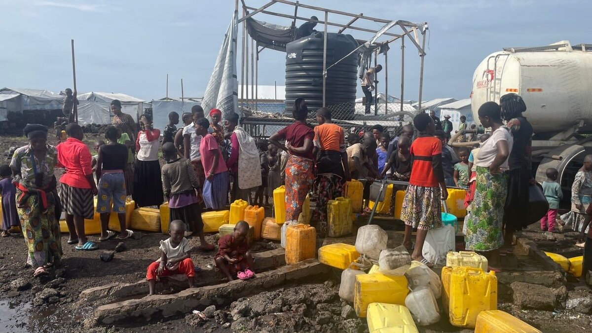 Numerous people queue for drinking water in a Congolese refugee camp