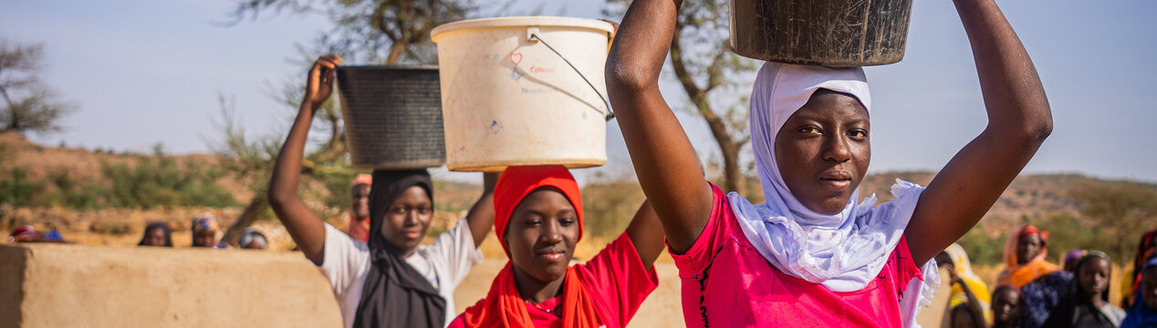Mädchen an einem Brunnen in Mali