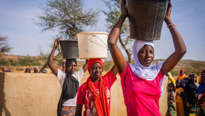 Mädchen an einem Brunnen in Mali
