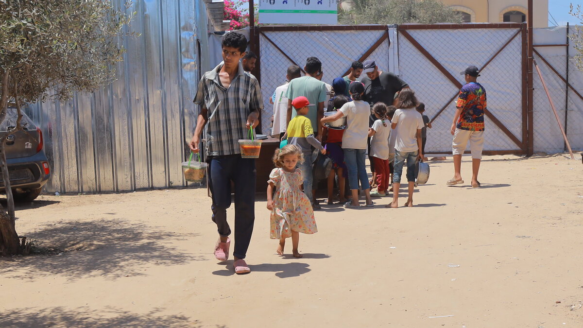 Verteilung von warmen Mahlzeiten in Gaza Ein Mann und ein Kind haben warme Mahlzeiten erhalten