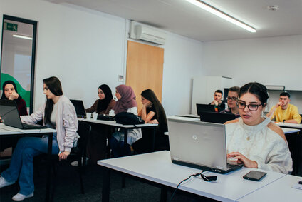 Junge Menschen arbeiten an Laptops