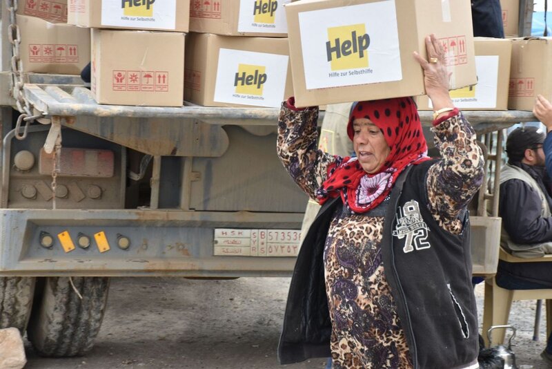 Frau mit Help-Hilfspaket in Syrien