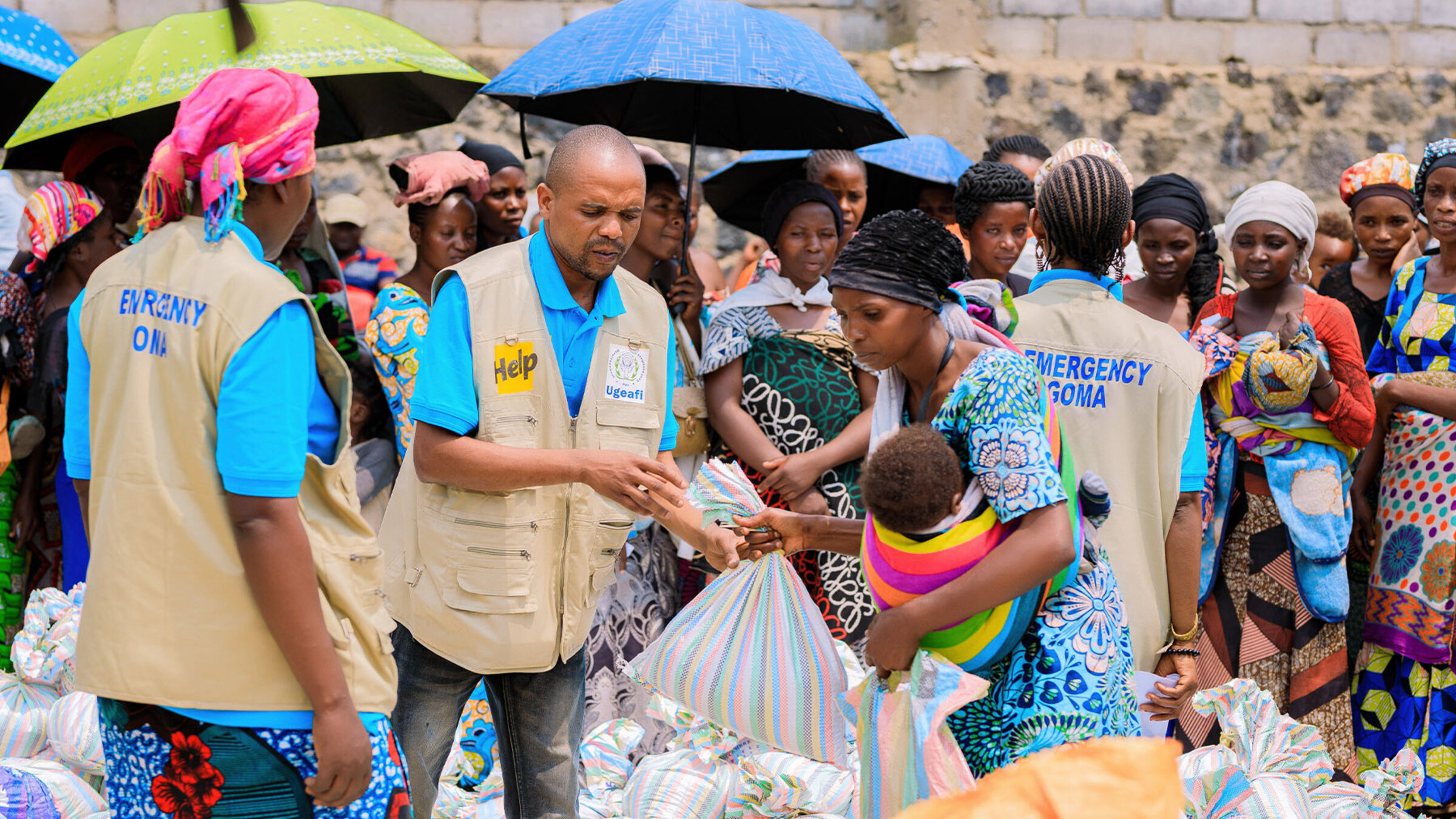 Humanitarian aid workers distribute sacks of rice and beans to displaced people in Congo