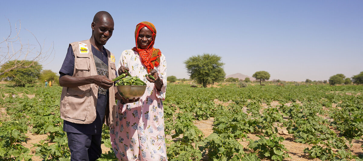 Eine Farmerin und ein Mitarbeiter der Partnerorganisation von Help im Tschad auf einem Feld